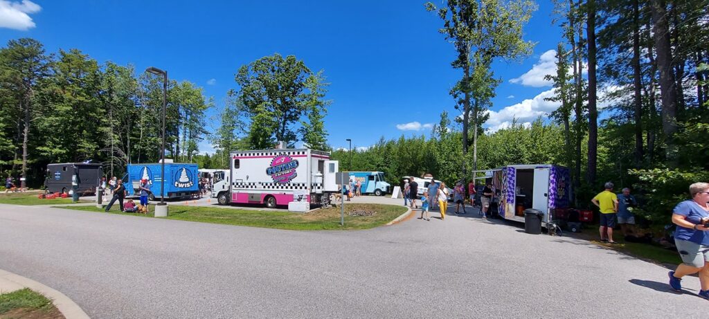 a dozen food trucks lined up on pavement during Woofstock Festival
