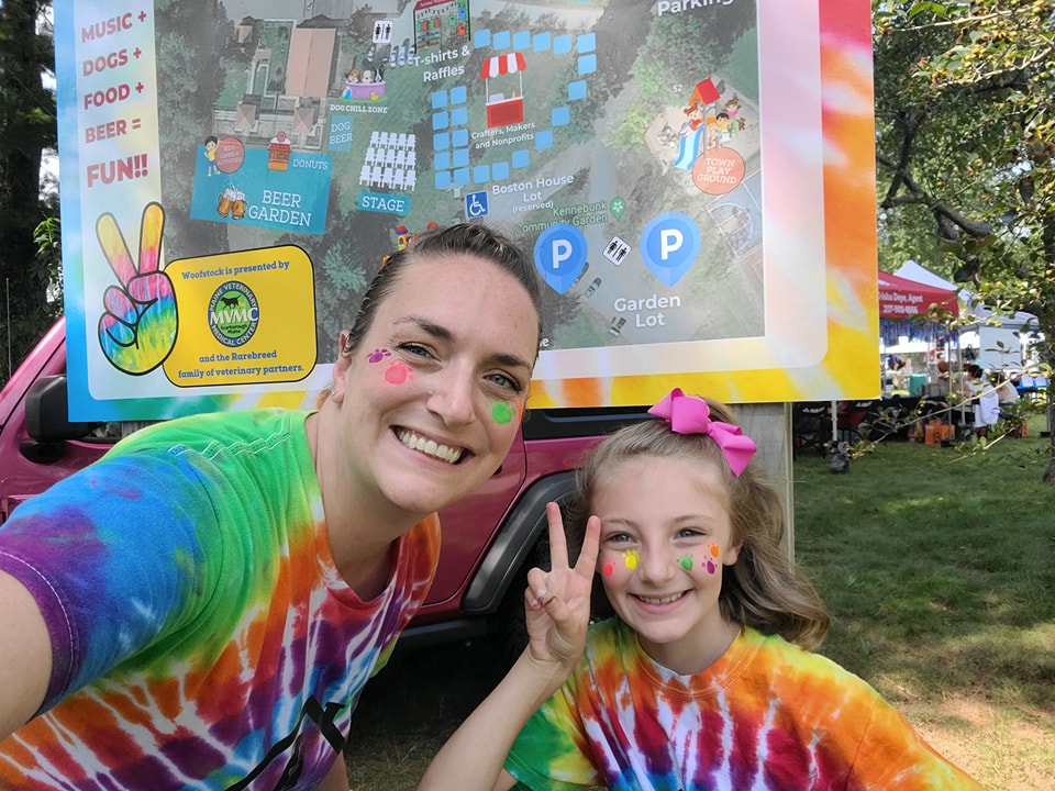 Mother and daughter with face paint smile at Woofstock Festival