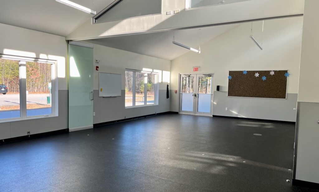 panorama of canine training's empty classroom, showing grey floor and big bright windows