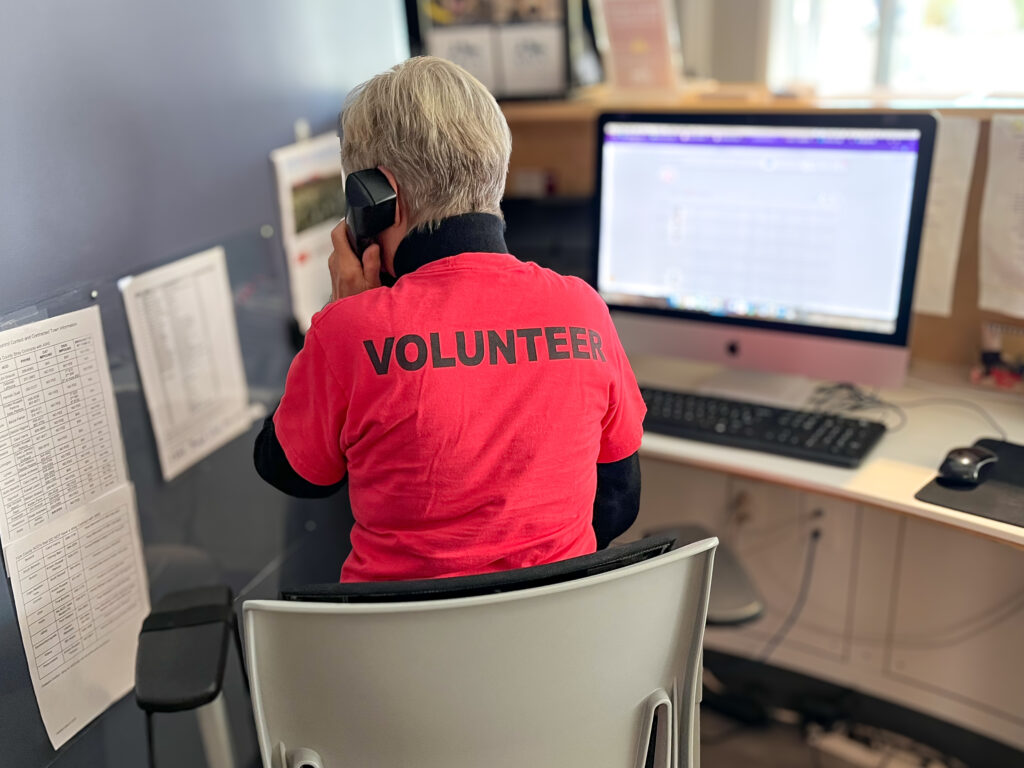 An AWS volunteer working the front desk in the Adoption Center.