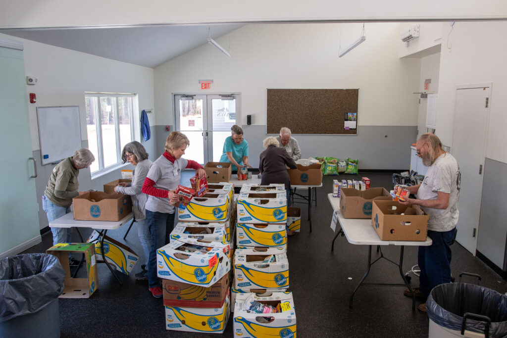 A team of AWS volunteers sort through a large donation from Hannaford.
