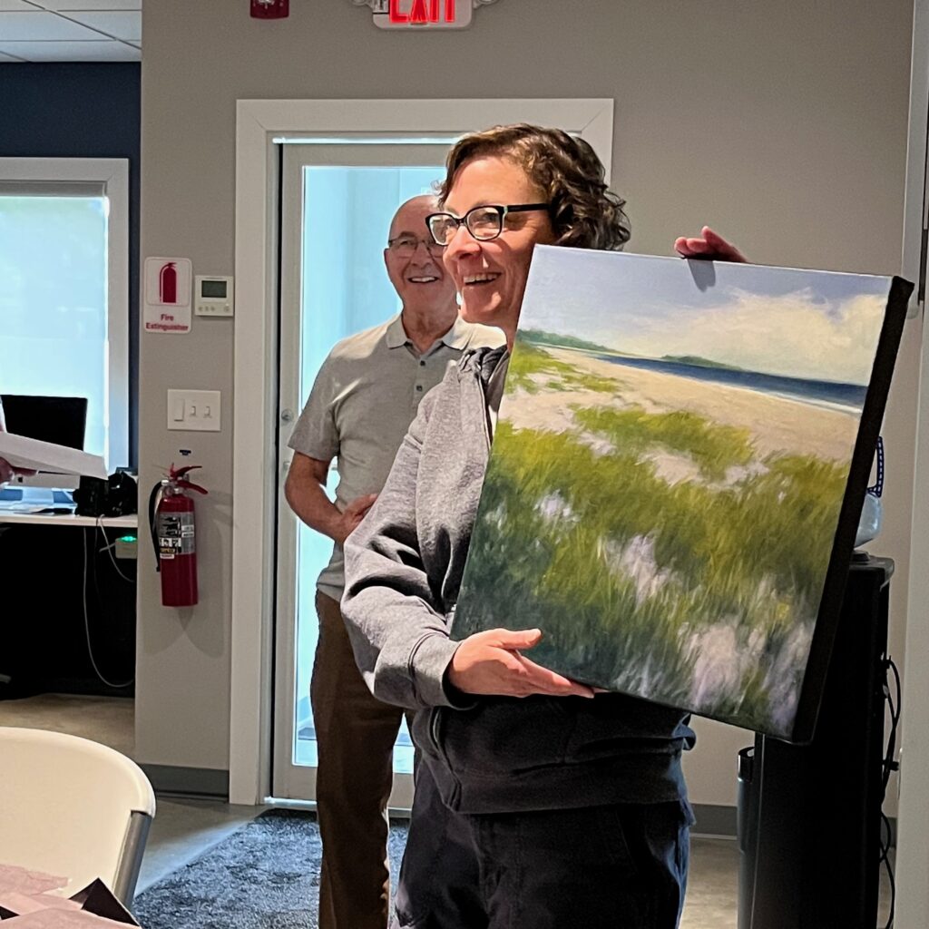 Abigail smiles after receiving a thank you gift from AWS staff and board