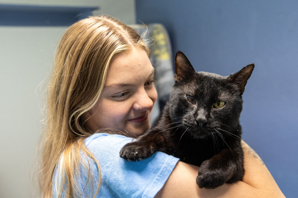 Take a bet on Black Jack, the adorable black cat being held by an AWS staff member.