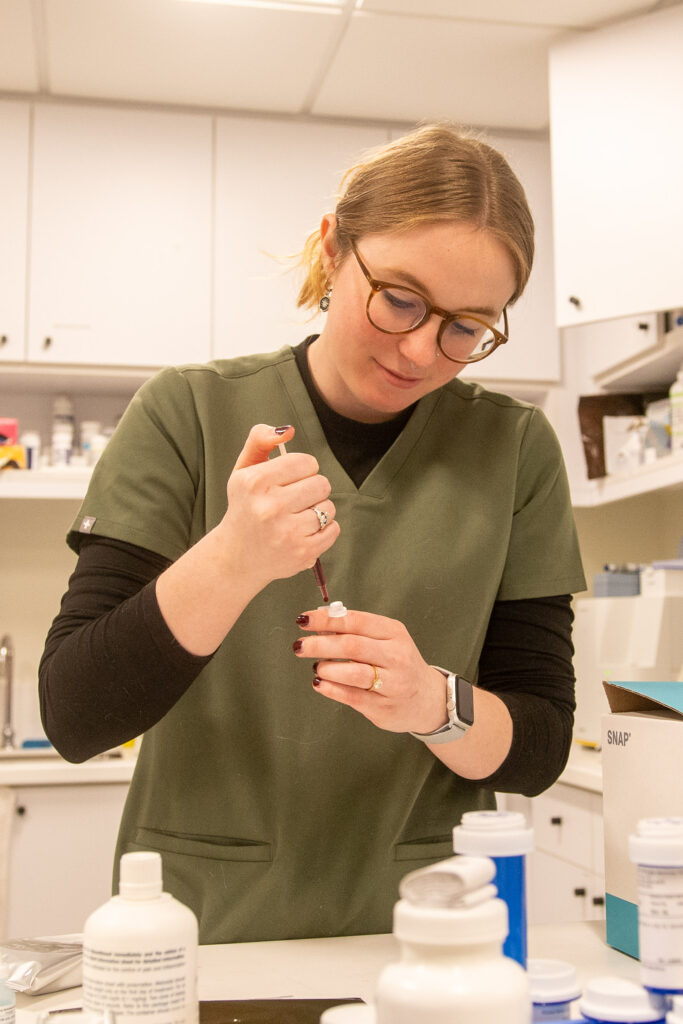 An AWS veterinary technician fills a syringe.