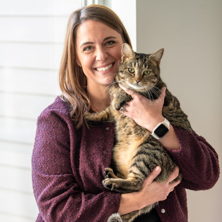 Executive Director Heidi Marston poses with a brown tabby cat